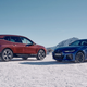 A photo of a BMW iX SUV and BMW i4 electric sedan on snow.